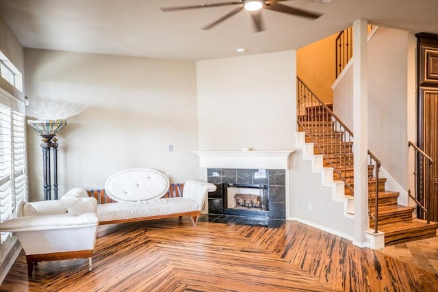 unfurnished living room featuring parquet floors, a tile fireplace, and ceiling fan