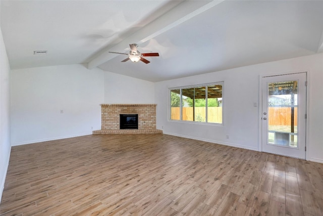 unfurnished living room with ceiling fan, lofted ceiling with beams, a brick fireplace, and light hardwood / wood-style flooring