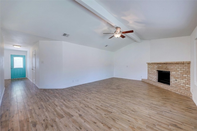 unfurnished living room featuring a brick fireplace, lofted ceiling with beams, ceiling fan, and light wood-type flooring