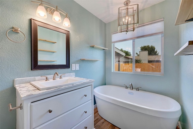 bathroom featuring hardwood / wood-style floors, vanity, and a washtub