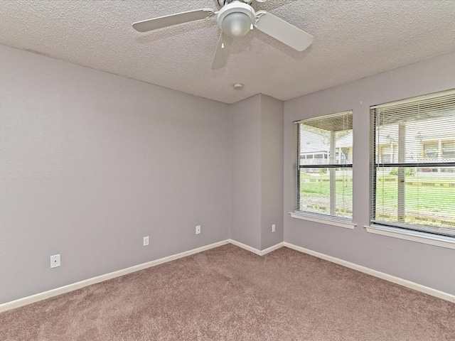 carpeted spare room with ceiling fan and a textured ceiling