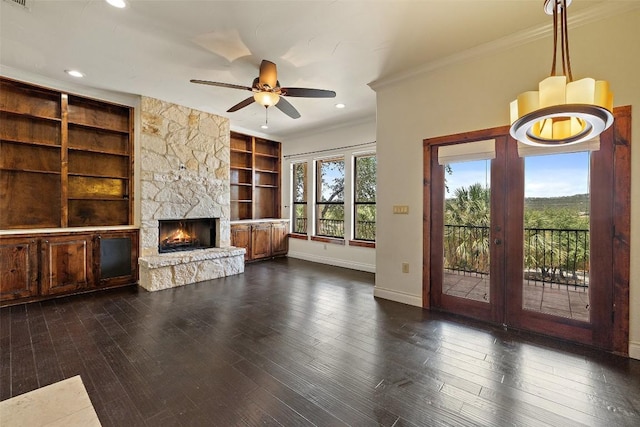 201 Cowal Dr N, Spicewood, TX 78669 - unfurnished living room with ornamental molding, baseboards, built in features, ceiling fan, and a stone fireplace