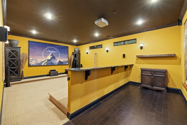 cinema room featuring crown molding and dark hardwood / wood-style floors