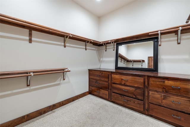 walk in closet featuring light carpet