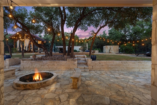 patio terrace at dusk featuring a fire pit