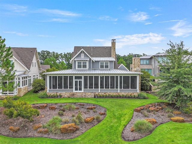 rear view of property with a yard and a sunroom