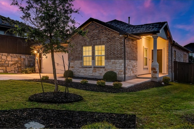 property exterior at dusk featuring a garage and a yard