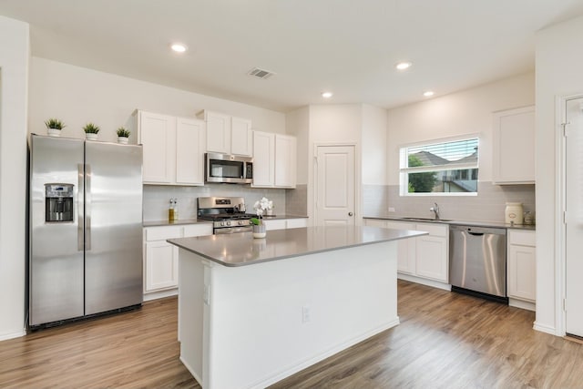 kitchen with a kitchen island, sink, white cabinetry, and stainless steel appliances