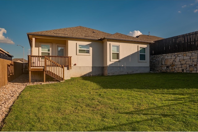 rear view of property featuring a lawn