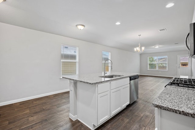 kitchen featuring hanging light fixtures, white cabinetry, sink, and a kitchen island with sink