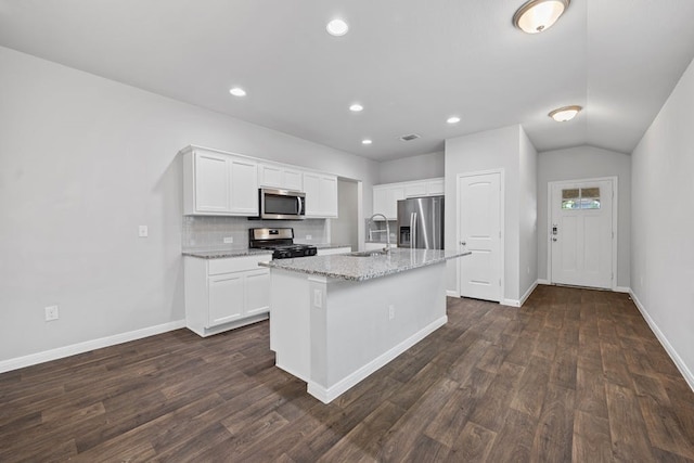 kitchen with a center island with sink, appliances with stainless steel finishes, sink, light stone counters, and white cabinetry