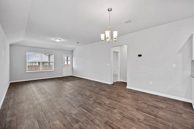 spare room featuring dark hardwood / wood-style flooring and a notable chandelier