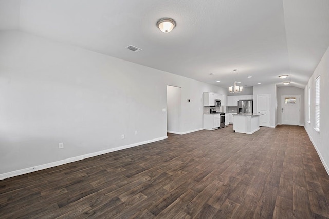 unfurnished living room with lofted ceiling, dark hardwood / wood-style flooring, and a notable chandelier