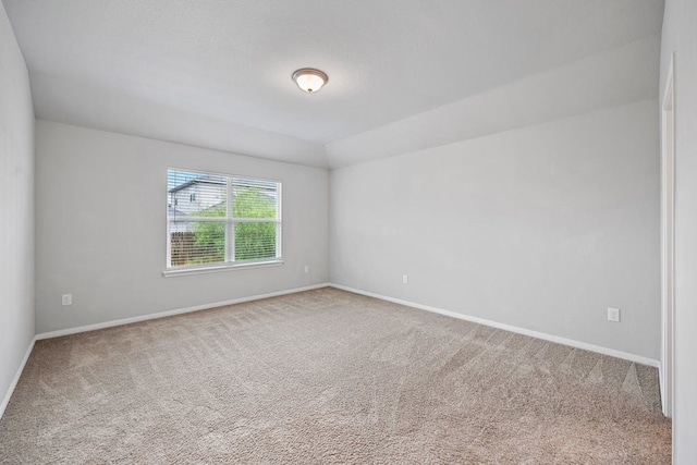 unfurnished room featuring vaulted ceiling and carpet floors