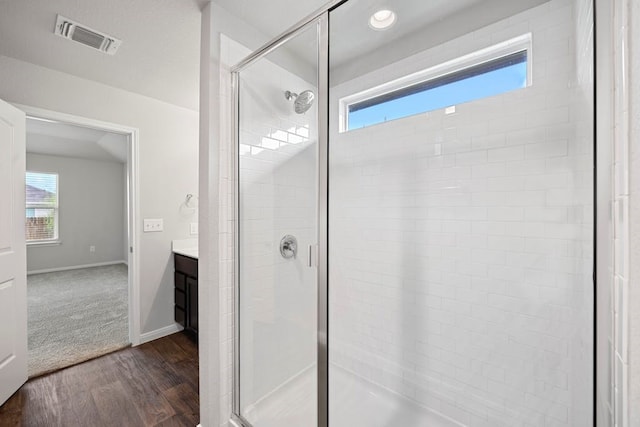 bathroom featuring vanity, a shower with door, and hardwood / wood-style floors