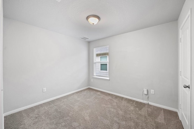 carpeted empty room with a textured ceiling