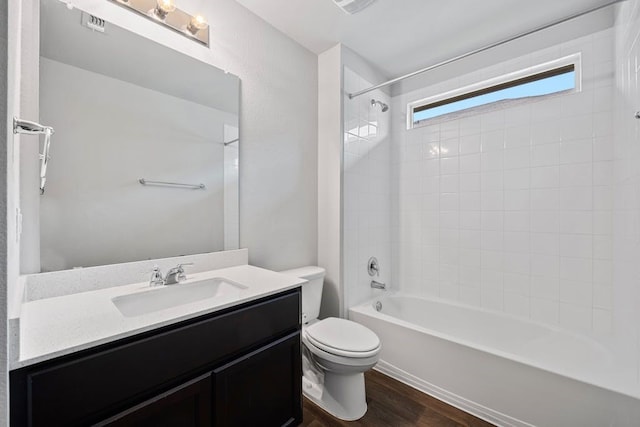 full bathroom featuring tiled shower / bath combo, wood-type flooring, vanity, and toilet