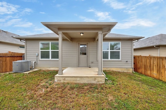 rear view of house featuring a patio, central AC unit, and a lawn