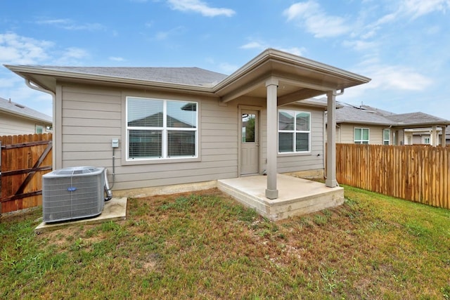 rear view of property featuring central AC, a patio, and a lawn