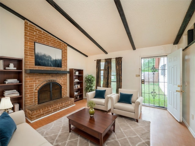 living room with a fireplace, lofted ceiling with beams, brick wall, and plenty of natural light