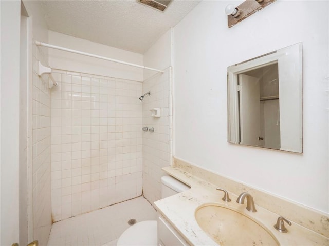 bathroom with visible vents, toilet, a textured ceiling, a shower stall, and vanity