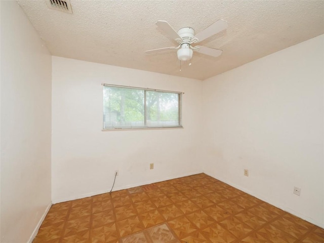 spare room featuring visible vents, a textured ceiling, and a ceiling fan