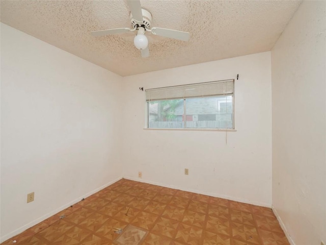 empty room featuring baseboards, a textured ceiling, and a ceiling fan