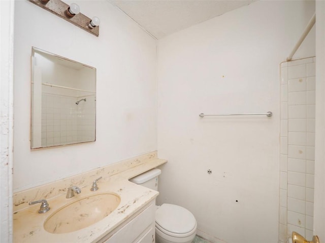 bathroom featuring vanity, toilet, and walk in shower