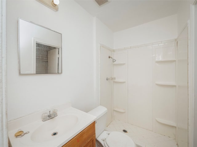 bathroom featuring walk in shower, toilet, and vanity