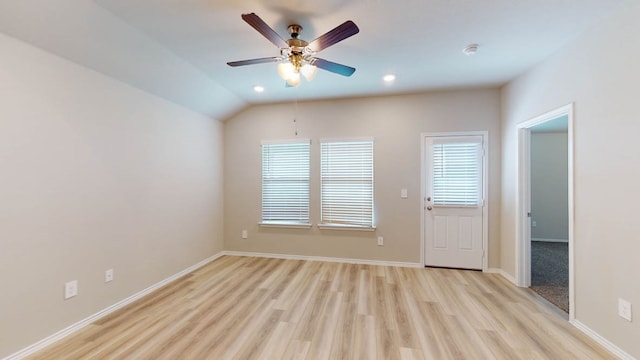 empty room with vaulted ceiling, ceiling fan, and light hardwood / wood-style flooring