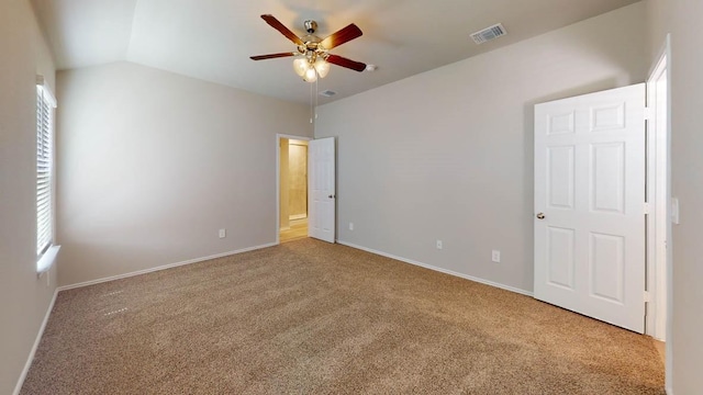 unfurnished bedroom with multiple windows, vaulted ceiling, carpet flooring, and ceiling fan