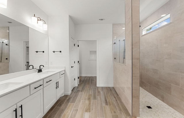 105 Riversong Cv, Georgetown, TX 78633 - full bathroom featuring a walk in shower, wood finished floors, double vanity, and baseboards
