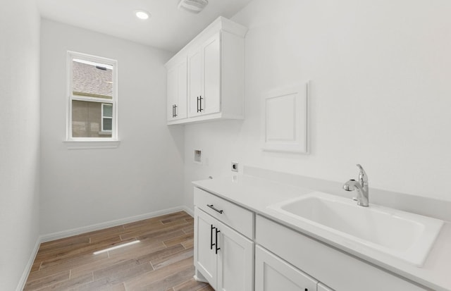 105 Riversong Cv, Georgetown, TX 78633 - washroom featuring hookup for an electric dryer, washer hookup, light wood finished floors, baseboards, and cabinet space