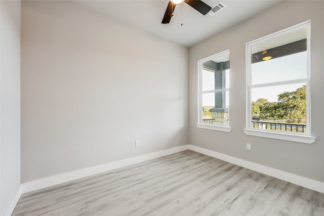 empty room with ceiling fan and light hardwood / wood-style flooring