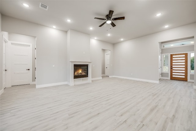 unfurnished living room with light wood-type flooring and ceiling fan