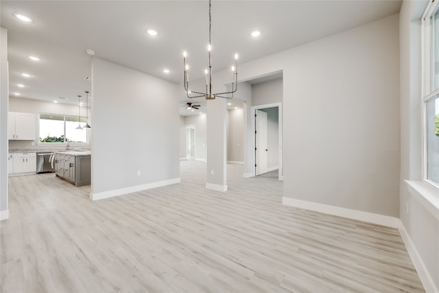 unfurnished living room with light hardwood / wood-style flooring and ceiling fan with notable chandelier