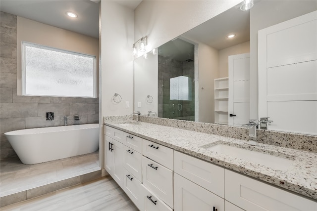 bathroom featuring independent shower and bath and dual bowl vanity