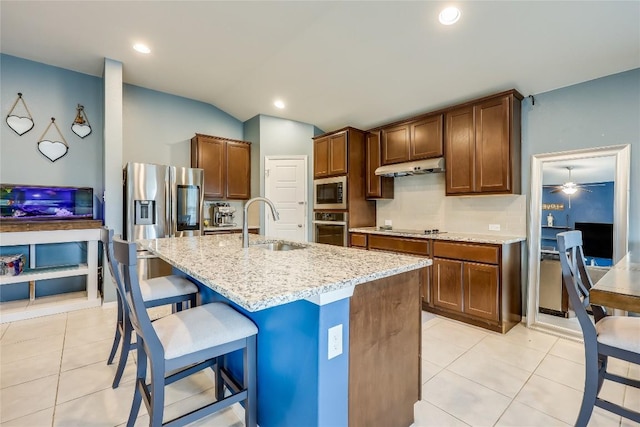 20400 Bear Rd, Lago Vista, TX 78645 - kitchen featuring stainless steel appliances, a sink, under cabinet range hood, light stone countertops, and a breakfast bar