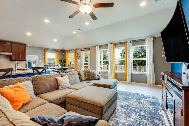 tiled living room featuring ceiling fan, sink, and vaulted ceiling