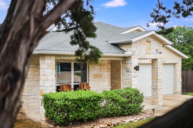 20400 Bear Rd, Lago Vista, TX 78645 - view of front of property featuring an attached garage, fence, a shingled roof, and stone siding