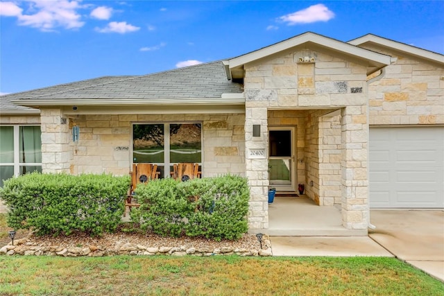 20400 Bear Rd, Lago Vista, TX 78645 - view of front of property featuring stone siding, a shingled roof, and an attached garage