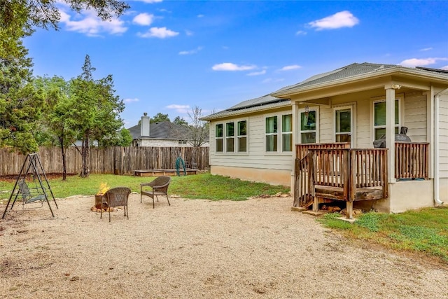 20400 Bear Rd, Lago Vista, TX 78645 - rear view of house with a fire pit, solar panels, and a fenced backyard