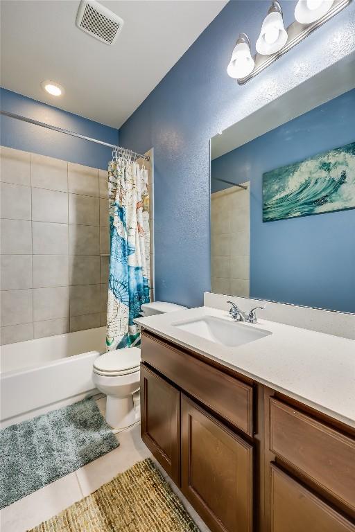 20400 Bear Rd, Lago Vista, TX 78645 - full bathroom with vanity, toilet, shower / bath combination with curtain, tile patterned floors, and a textured wall