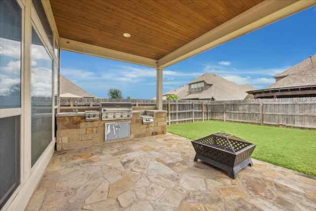 view of patio featuring an outdoor kitchen, an outdoor fire pit, and a grill