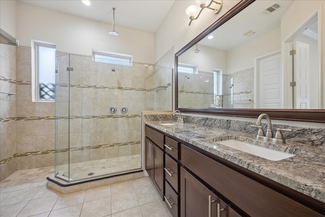 bathroom featuring dual vanity, tile patterned flooring, and walk in shower