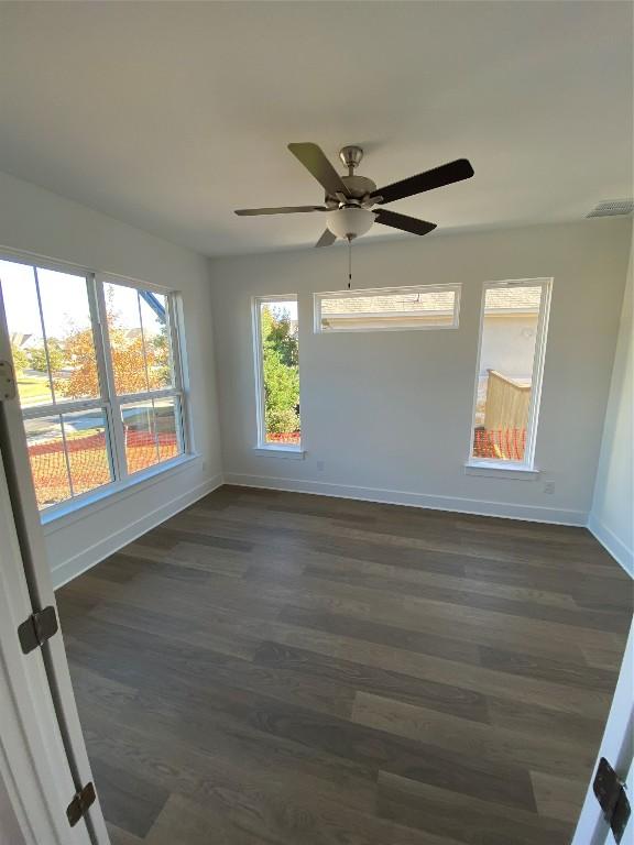 unfurnished room with ceiling fan and dark hardwood / wood-style floors