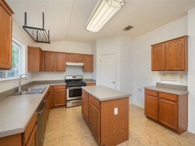 kitchen featuring appliances with stainless steel finishes, a center island, light tile patterned floors, and sink