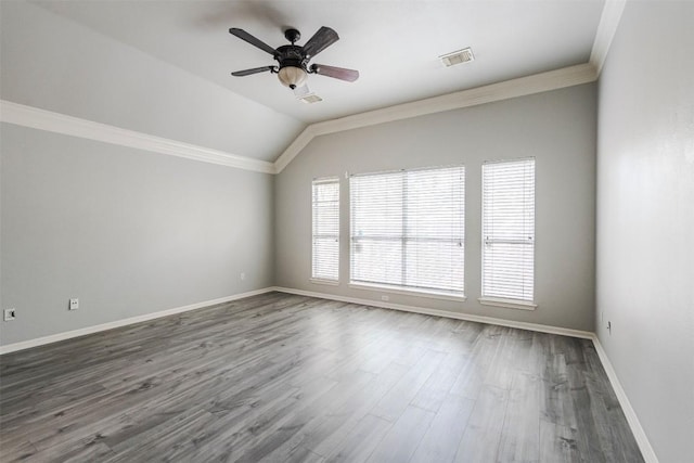 empty room with crown molding, vaulted ceiling, ceiling fan, and dark hardwood / wood-style flooring