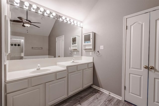 bathroom with lofted ceiling, vanity, wood-type flooring, and ceiling fan