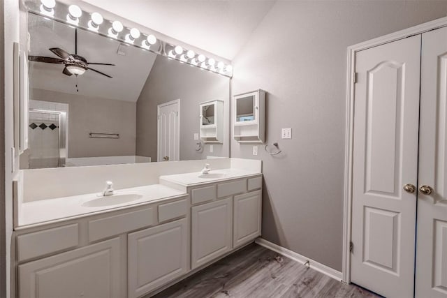6 Muirfield Greens Cv, Lakeway, TX 78738 - bathroom featuring lofted ceiling, double vanity, a ceiling fan, wood finished floors, and baseboards